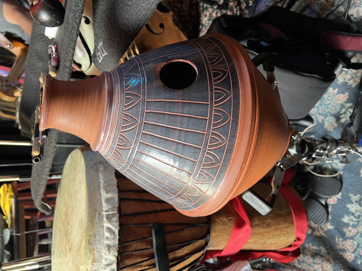 Close-up of the udu used in Come From Away, showing the mic hole with a rubber gasket that lets a lavalier mic be suspended inside the chamber